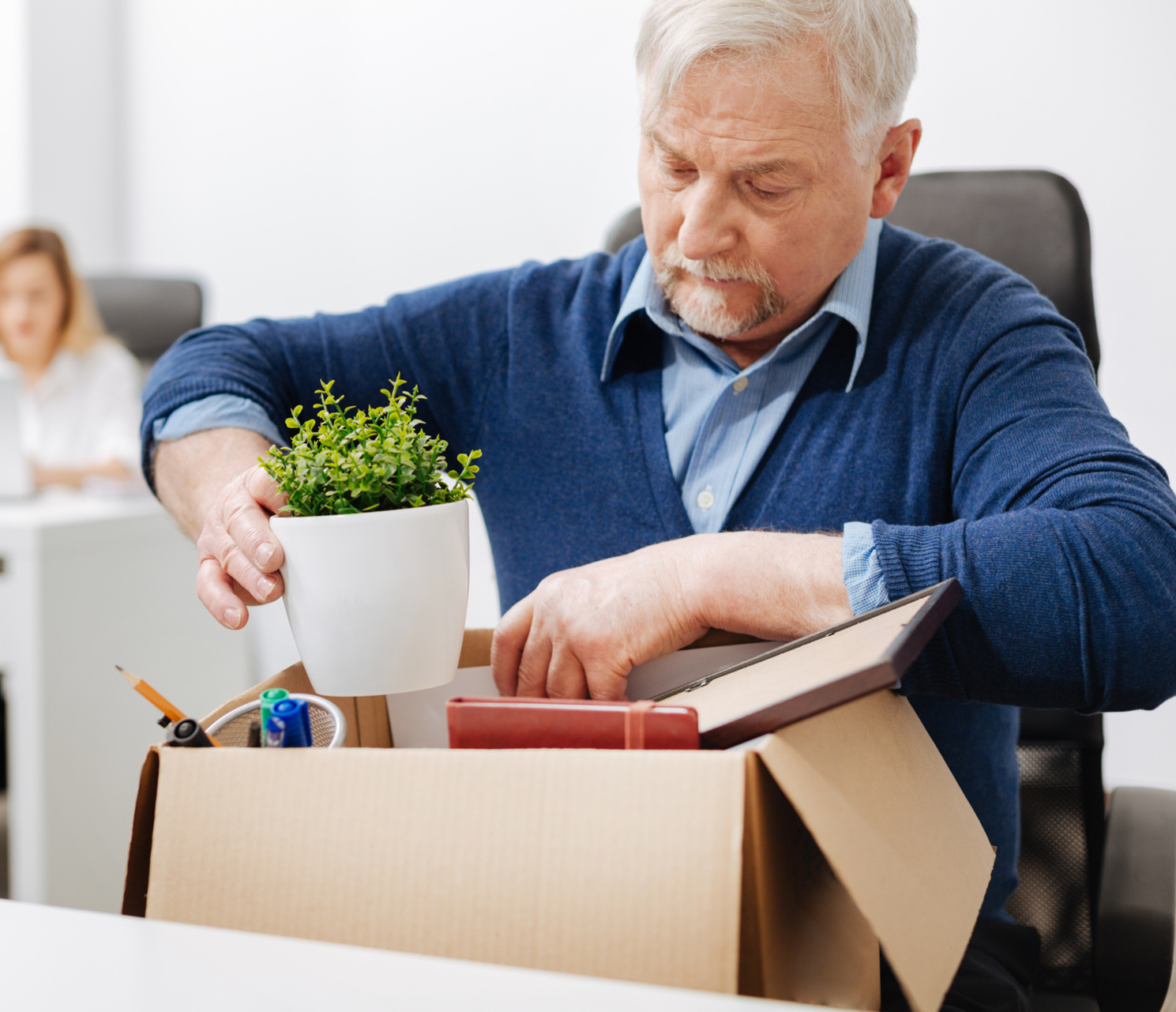 Man clearing his desk, preparing for redundancy process with a solicitor's guidance.