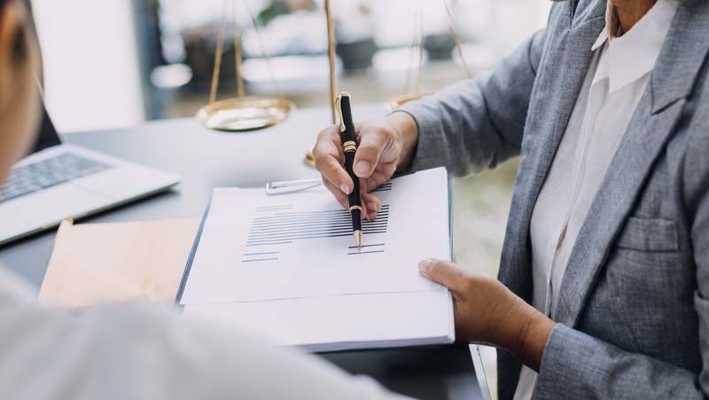 A litigation solicitor signing a legal document at a desk, focused on providing professional legal services.