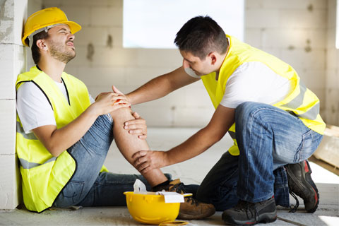 Construction worker injured on-site, receiving assistance from a work injury solicitor.