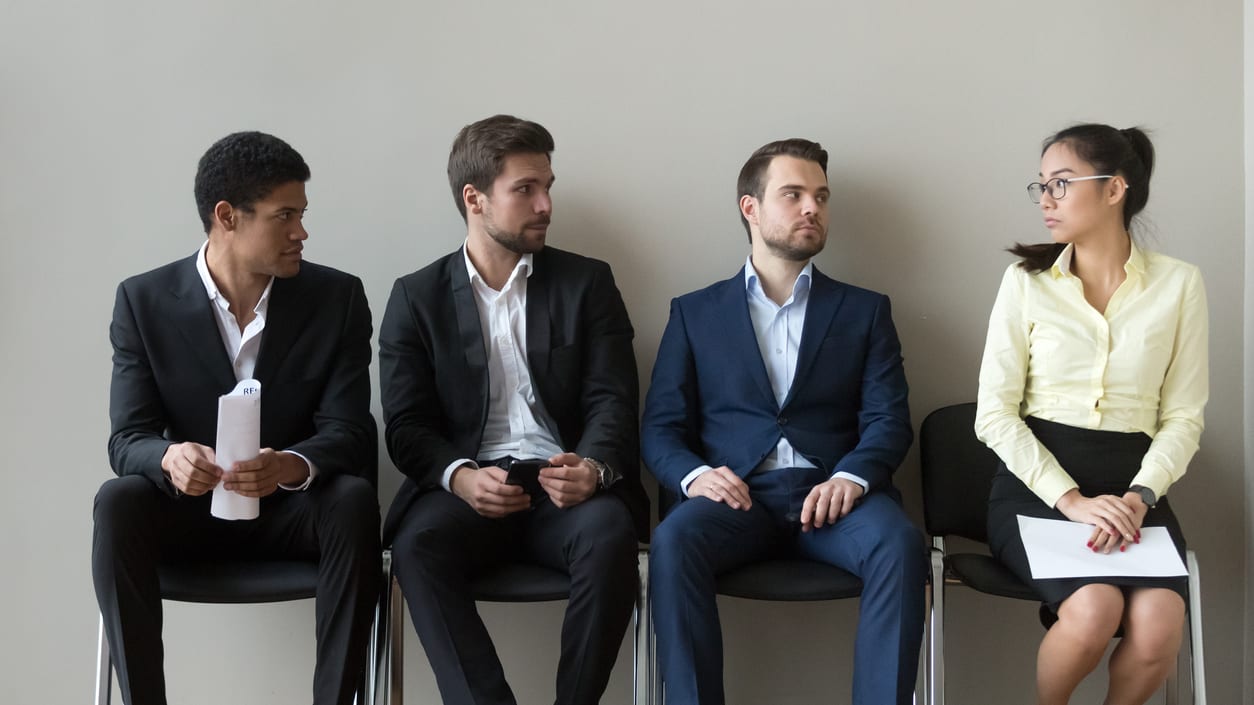 An office setting with an employee appearing uncomfortable as a colleague stands too close, symbolising workplace harassment.