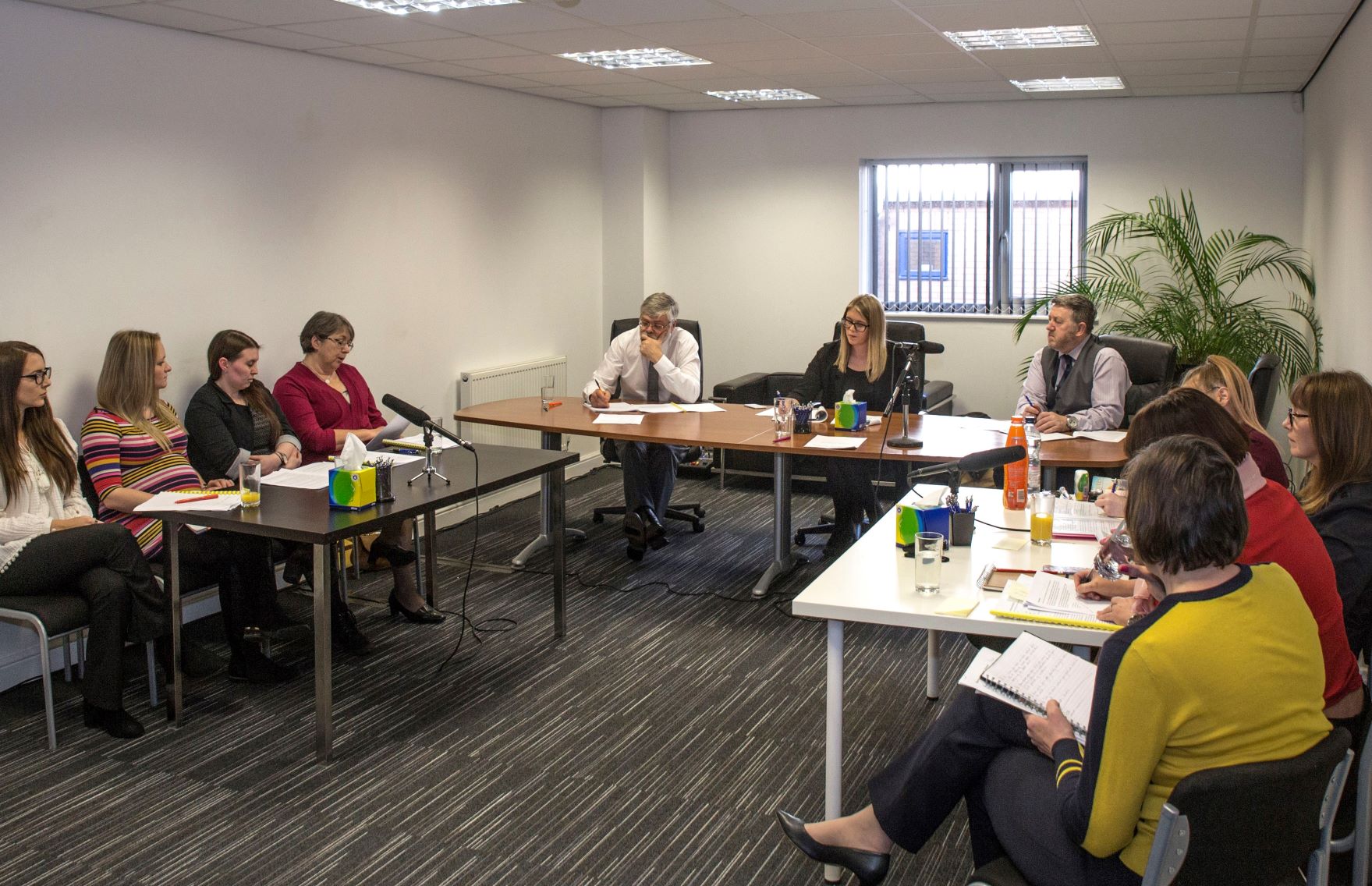 An office setting with an employee appearing uncomfortable as a colleague stands too close, symbolising workplace harassment.